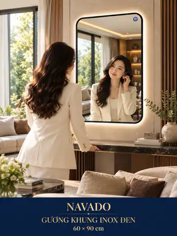 Gương khung inox đen 60 × 90 cm — phòng khách có bàn console và người mẫu Việt Nam